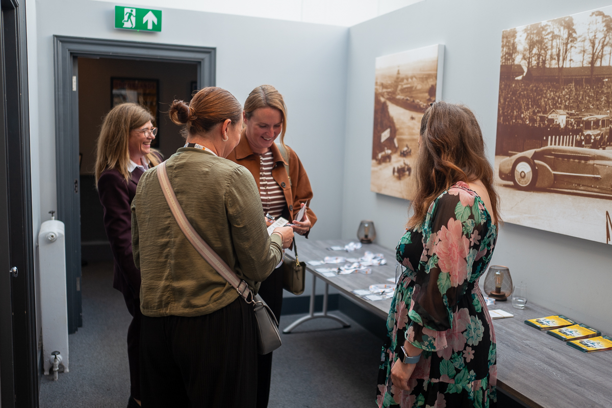 Guests collecting their name badges at the Concordia registration desk, Brooklands Museum
